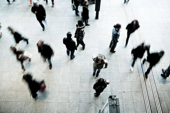 An overhead shot of people walking across a railway station