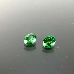 A Pair of Green Tsavorite, faceted oval, of 0.9 carats and 0.85 carat, very good, total of 1.75 carats.