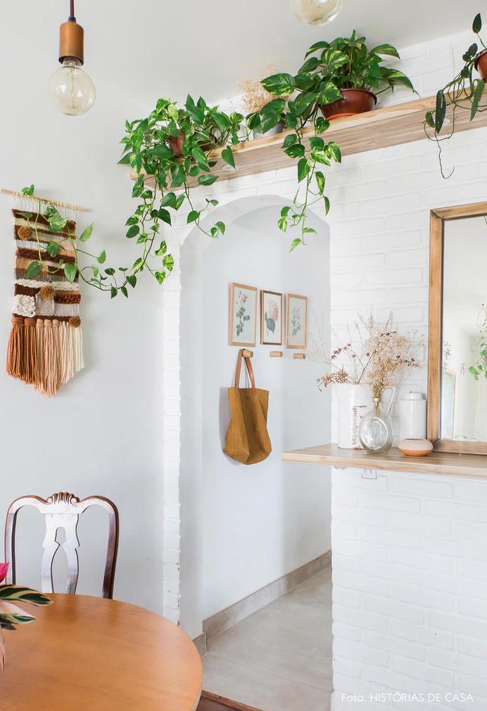Apartamento pequeno com parede de tijolinho branco e plantas