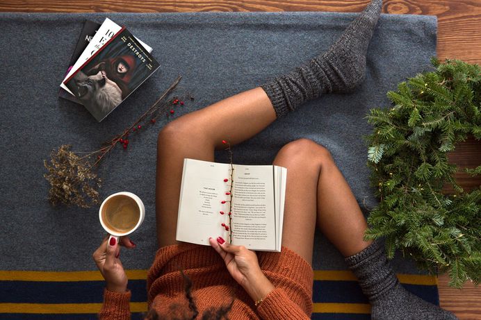 Woman reads book while drinking coffee for holiday photo by Thought Catalog (@thoughtcatalog) on Unsplash