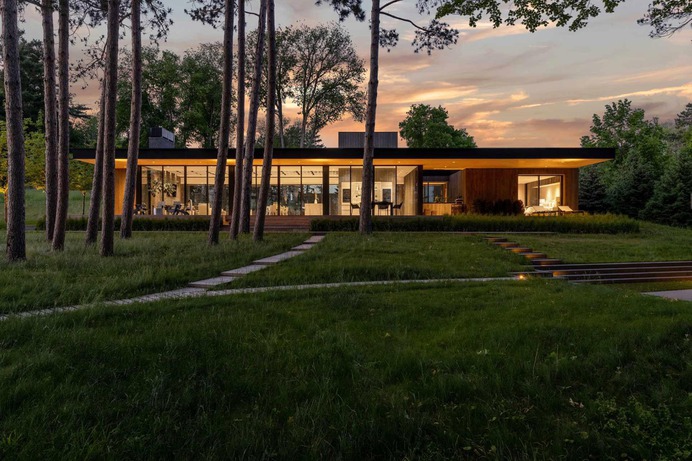 A Deep Overhanging Roof Covers The Glass Walls Of This Lake House
