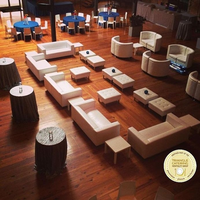 Large lounge area with white couches and ottomans at a corporate event in Durham, NC