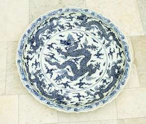 Extraordinary and particular large Chinese blue and white porcelain bowl with round shaped border, waved extended high border rim, decorated with a blue painted dragon in the centre with clouds and four dragons on the sides #Sets #Teasets #Porcelainsets #Antiqueplates #Plates #Wallplates #Figures #Porcelainfigurines #porcelain