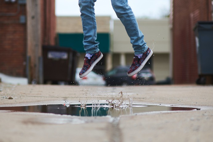 person jumping over body of water