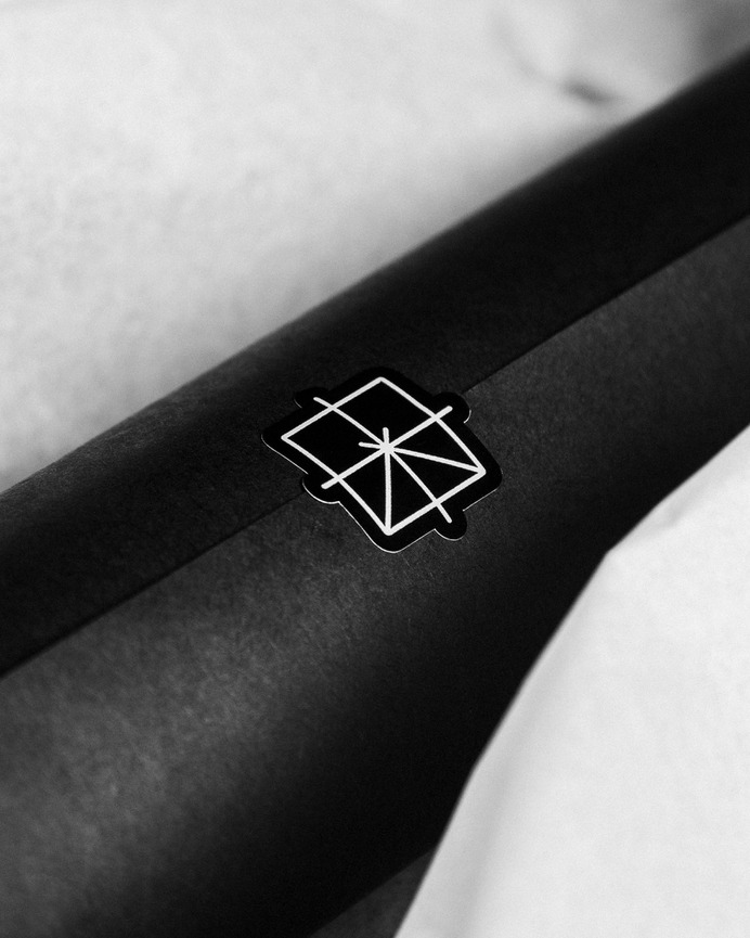 Tissue paper poster packaging with Geometry Club logo sticker for Sheffield architecture print