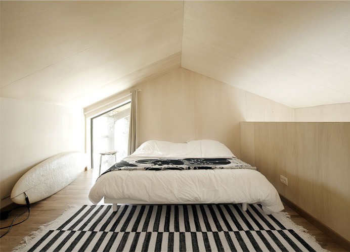 Beach Cottage Covered by a Dark Wood Cladding - InteriorZine