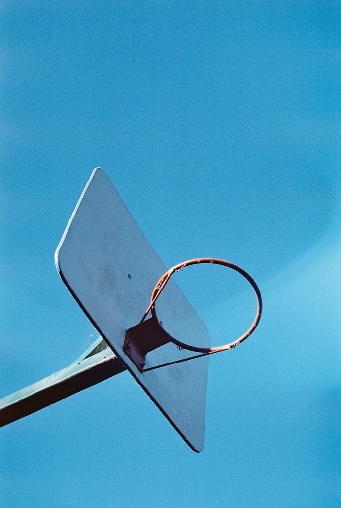 A baseball hoop without the net against a blue sky