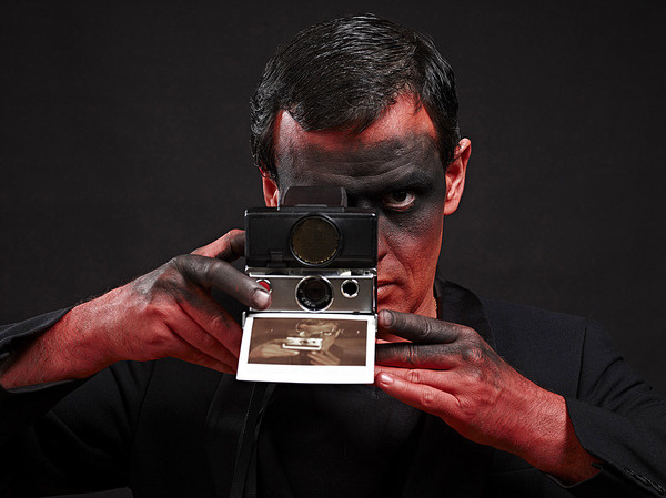 Man making a picture with vintage polaroid SX70 #red #photo #black #polaroid #paint #photography #raar #face