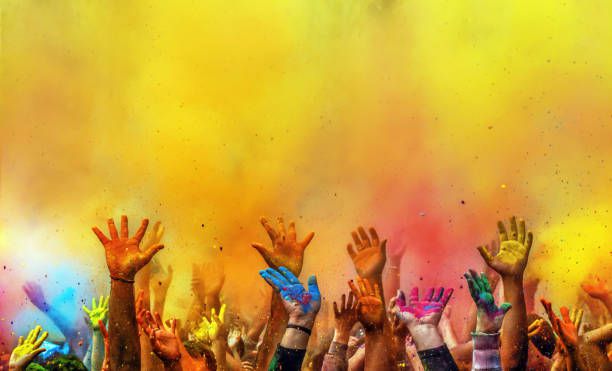 Hands painted with different colors raised up on Holi festival, Washington DC, USA