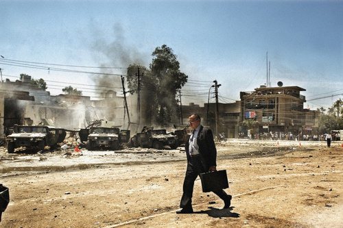 2004: Moises Saman. An Iraqi man walks by the scene of an attack on US Army Humvee that caused several American casualties in the Al-Waziriy #man #iraq #briefcase #old