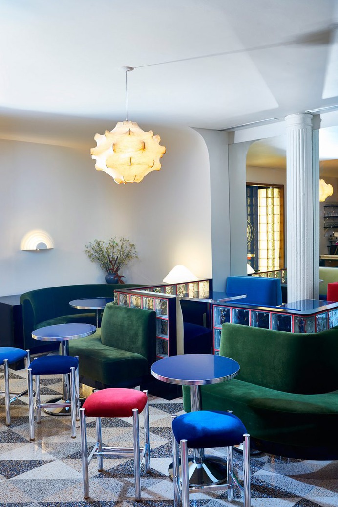 The front room is painted bright white with chrome tables and chairs resembling a vintage diner. The lamp is the Viscontea Cocoon Pendant by Achille & Pier Giacomo Castiglioni from 1960.