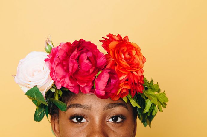 A woman with a crown of red and white flowers on her head