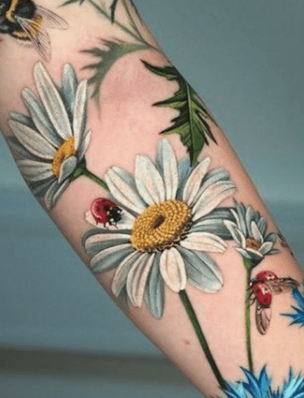 daisy tattoo with ladybugs on forearm