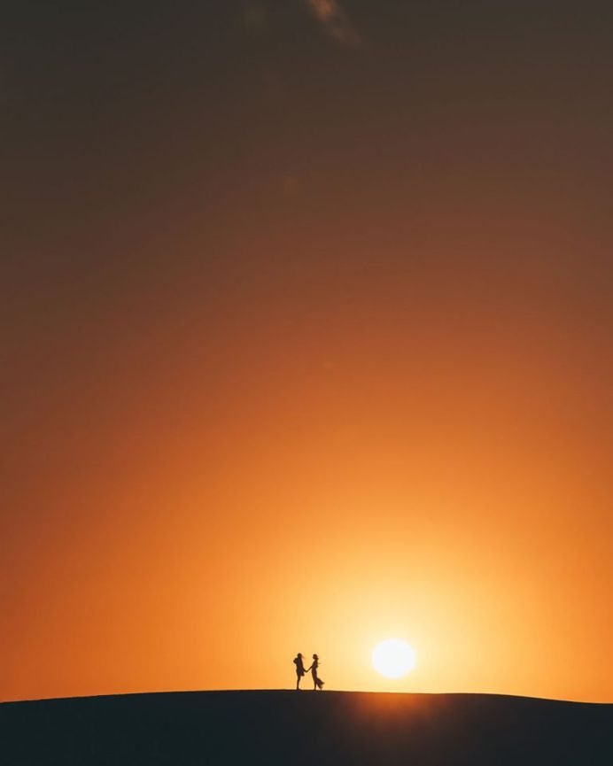 Um casal de mãos dadas a luz do sol